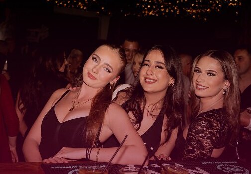 Guests smiling at the Trombar bar on a weekend night